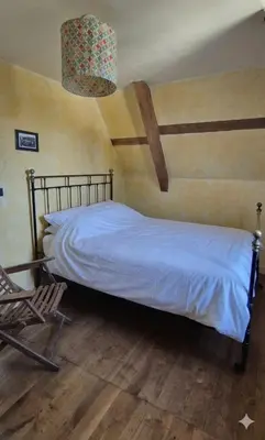 Un ou plusieurs lits dans un hébergement de l'établissement La Maison au Perroquet village typique en pierre