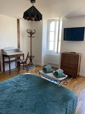 Télévision ou salle de divertissement dans l'établissement Le gîte de l’horloge