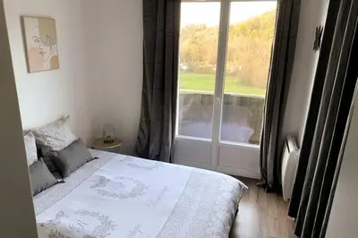 Un ou plusieurs lits dans un hébergement de l'établissement Logement à Brive près de la campagne et centre-ville, avec parking privé, climatisation, et double balcon privé