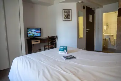 Un ou plusieurs lits dans un hébergement de l'établissement Logis Hotel Eben