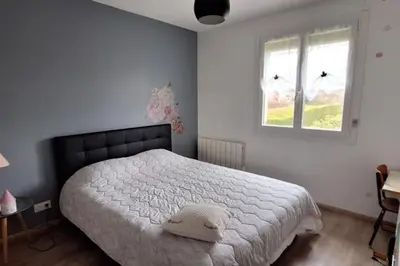 Un ou plusieurs lits dans un hébergement de l'établissement Charmante maison de ville climatisée avec Wifi