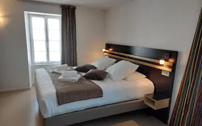 Un ou plusieurs lits dans un hébergement de l'établissement Logis Hôtel Restaurant Auberge de la Xaintrie