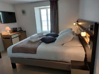 Un ou plusieurs lits dans un hébergement de l'établissement Logis Hôtel Restaurant Auberge de la Xaintrie