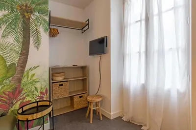 Télévision ou salle de divertissement dans l'établissement Les palmiers de Brive