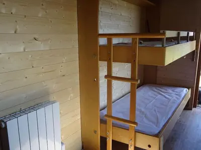 Un ou plusieurs lits superposés dans un hébergement de l'établissement Belle roulotte de style chalet au coeur du Sancy