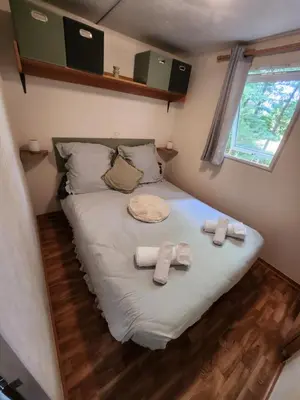 Un ou plusieurs lits dans un hébergement de l'établissement Mobilhome les pieds dans l eau avec piscine