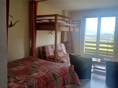 Un ou plusieurs lits dans un hébergement de l'établissement Studio à Besse-et-Saint-Anastaise avec parking et vue Monts du Cantal - FR-1-814-125