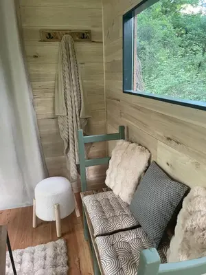 Coin salon dans l'établissement Ti'Nid, cabane chaleureuse plongée dans la nature
