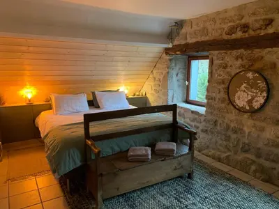 Un ou plusieurs lits dans un hébergement de l'établissement Ancien Prieure Chambre King Size avec sauna et bain nordique privatifs en extérieur