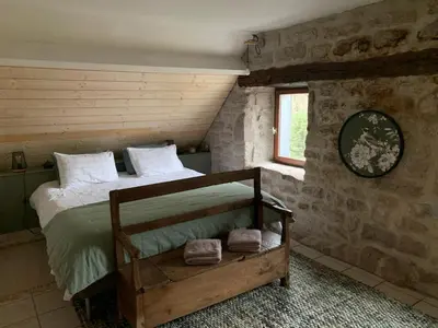Un ou plusieurs lits dans un hébergement de l'établissement Ancien Prieure Chambre King Size avec sauna et bain nordique privatifs en extérieur