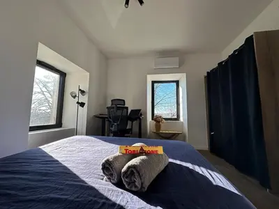 Un ou plusieurs lits dans un hébergement de l'établissement Maison avec jardin, wifi, parking, vidéo projecteur