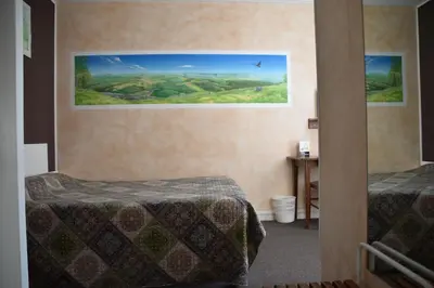 Un ou plusieurs lits dans un hébergement de l'établissement Hôtel Le Rider