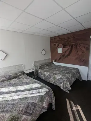 Un ou plusieurs lits dans un hébergement de l'établissement Hôtel Le Rider