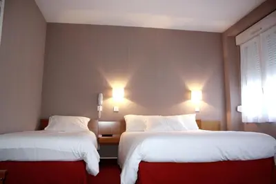 Un ou plusieurs lits dans un hébergement de l'établissement Hotel du Touring