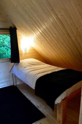 Un ou plusieurs lits dans un hébergement de l'établissement Les Lodges Du Reynou
