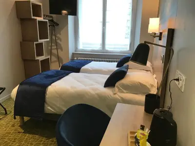 Un ou plusieurs lits dans un hébergement de l'établissement Logis Hôtel de Paris
