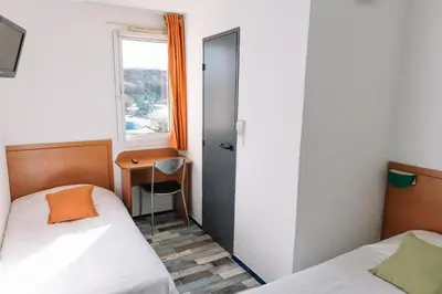 Un ou plusieurs lits dans un hébergement de l'établissement Welcomotel Limoges