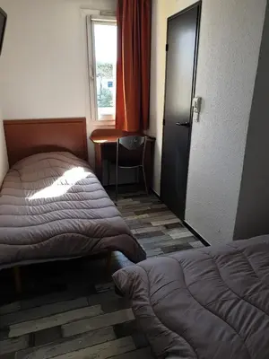 Un ou plusieurs lits dans un hébergement de l'établissement Welcomotel Limoges