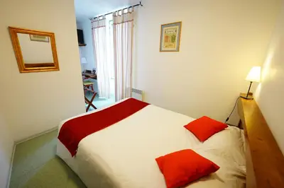 Un ou plusieurs lits dans un hébergement de l'établissement Logis Hôtel Le Relais Des Remparts