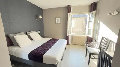 Un ou plusieurs lits dans un hébergement de l'établissement Logis Hotel Restaurant des Voyageurs