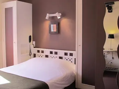 Un ou plusieurs lits dans un hébergement de l'établissement Logis Hôtel Deshors-Foujanet