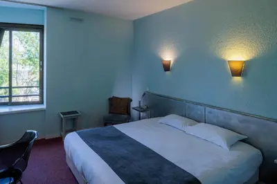 Un ou plusieurs lits dans un hébergement de l'établissement Logis Hotel Noemys Brive - Restaurant Le Teinchurier