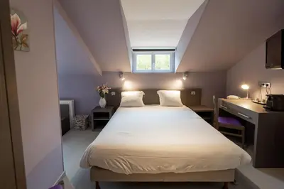 Un ou plusieurs lits dans un hébergement de l'établissement Logis Central Hôtel - Restaurant & Spa