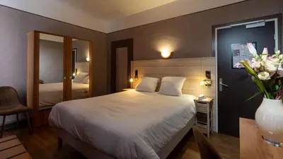 Un ou plusieurs lits dans un hébergement de l'établissement Logis Central Hôtel - Restaurant & Spa