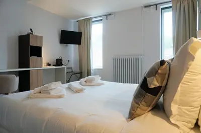 Un ou plusieurs lits dans un hébergement de l'établissement Logis Hôtel Le Confluent