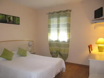 Un ou plusieurs lits dans un hébergement de l'établissement Hôtel Le Colombier