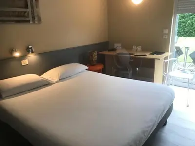 Un ou plusieurs lits dans un hébergement de l'établissement Logis Hotel Les Gravades Ussel