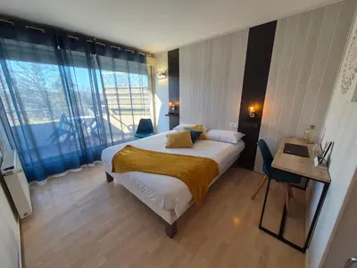 Un ou plusieurs lits dans un hébergement de l'établissement Logis Hotel Les Gravades Ussel