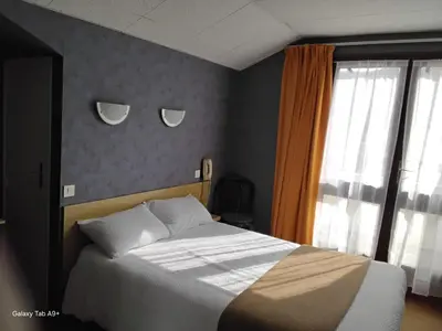 Un ou plusieurs lits dans un hébergement de l'établissement Logis Hôtel L'Elancèze