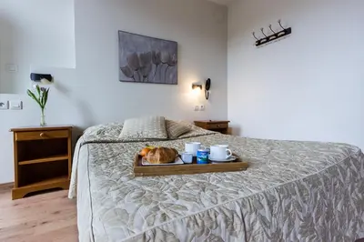 Un ou plusieurs lits dans un hébergement de l'établissement Logis Hôtel Regina