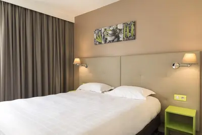 Un ou plusieurs lits dans un hébergement de l'établissement BRIT HOTEL Confort Le Limouzi TULLE