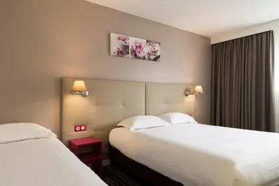 Un ou plusieurs lits dans un hébergement de l'établissement BRIT HOTEL Confort Le Limouzi TULLE
