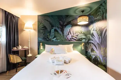 Un ou plusieurs lits dans un hébergement de l'établissement Hôtel Grand Confort Le Moulin Rouge
