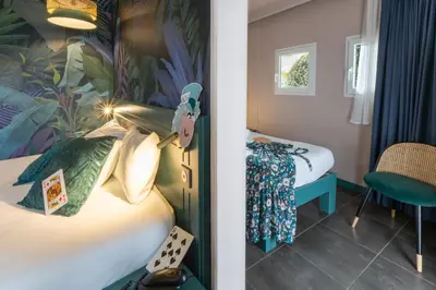 Un ou plusieurs lits dans un hébergement de l'établissement Hôtel Grand Confort Le Moulin Rouge