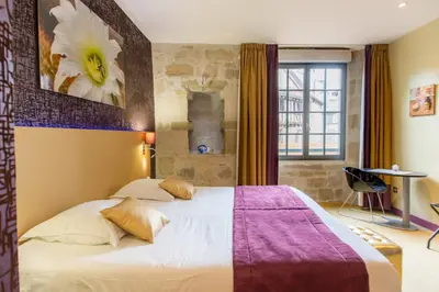 Un ou plusieurs lits dans un hébergement de l'établissement Charme et Caractère Le Turenne - Contact Hôtels