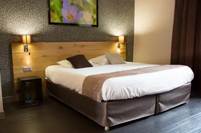 Un ou plusieurs lits dans un hébergement de l'établissement Charme et Caractère Le Turenne - Contact Hôtels