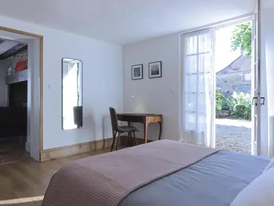Un ou plusieurs lits dans un hébergement de l'établissement Charmante maison en pierre avec jardin, cheminée et Wifi - FR-1-616-239