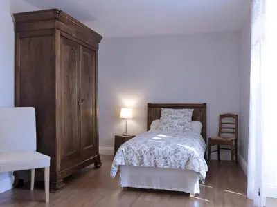 Un ou plusieurs lits dans un hébergement de l'établissement Charmante maison en pierre avec jardin, cheminée et Wifi - FR-1-616-239