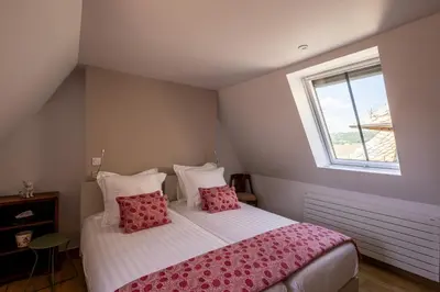 Un ou plusieurs lits dans un hébergement de l'établissement Chez Mimi - La Petite Tour