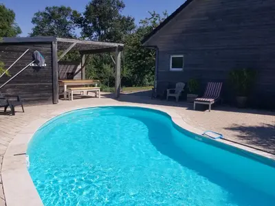 Piscine de l'établissement Gîte de la Tuillère, maison contemporaine en bois avec vue et piscine ou située à proximité