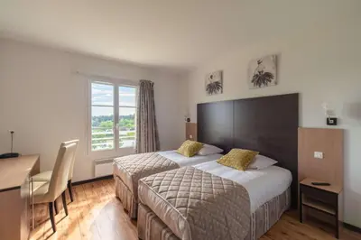 Un ou plusieurs lits dans un hébergement de l'établissement Brit Hotel Confort - La Tour Blanche