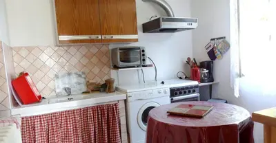 Cuisine ou kitchenette dans l'établissement Maison de charme à Teyssieu avec cheminée et jardin.