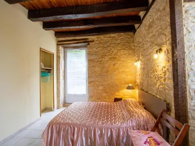 Un ou plusieurs lits dans un hébergement de l'établissement Charmante maison en pierre avec jardin clos, Tourtoirac - FR-1-616-280